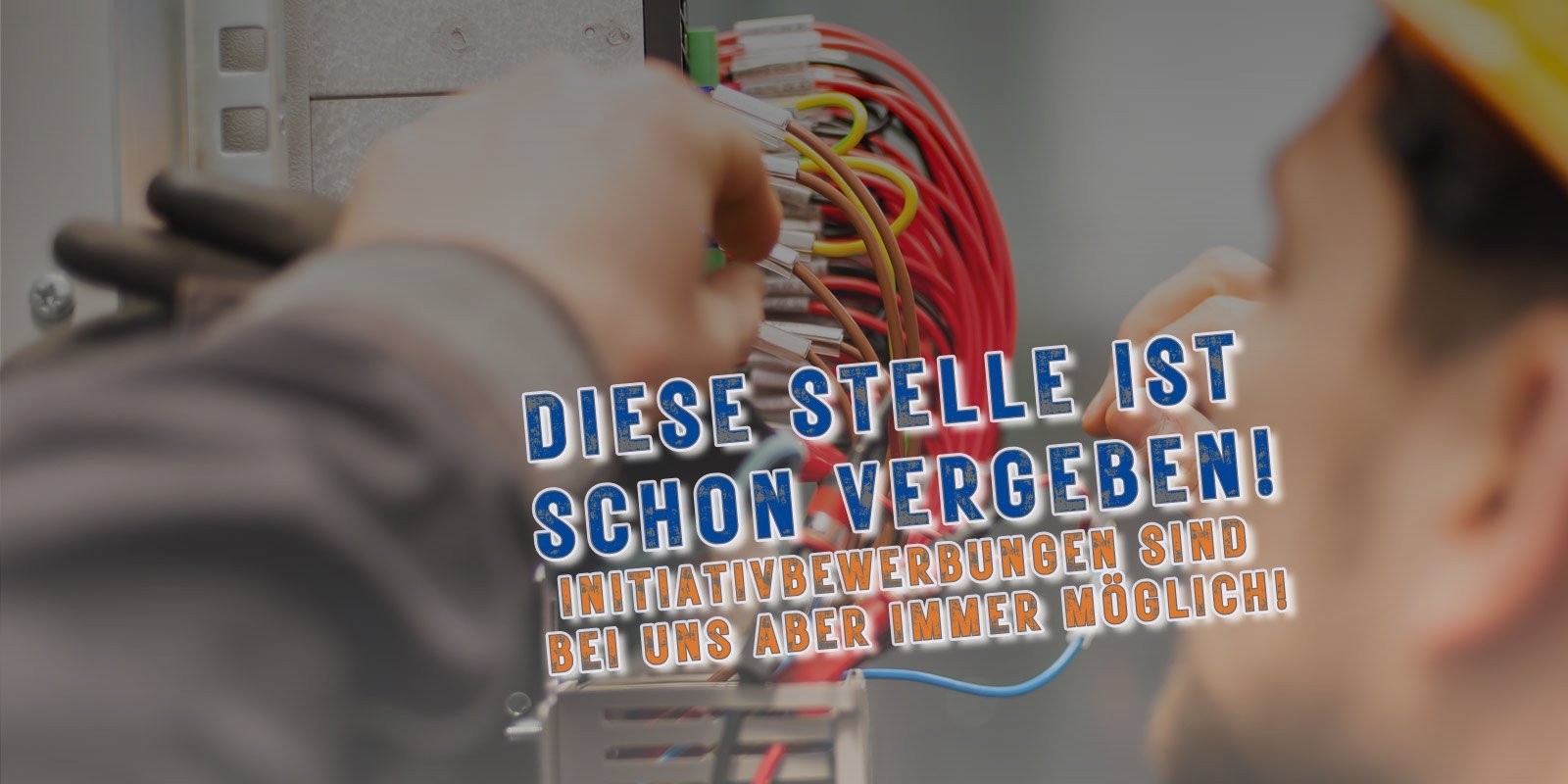 Ein Arbeiter verbindet bunte Kabel in einem elektrischen Schaltschrank, während er konzentriert auf seine Aufgabe schaut.