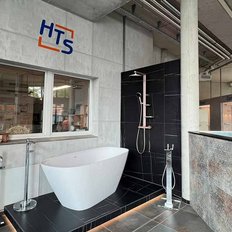 Ein modernes Badezimmer mit einer freistehenden Badewanne und einer eleganten Dusche in einem stilvollen Ausstellungsraum.