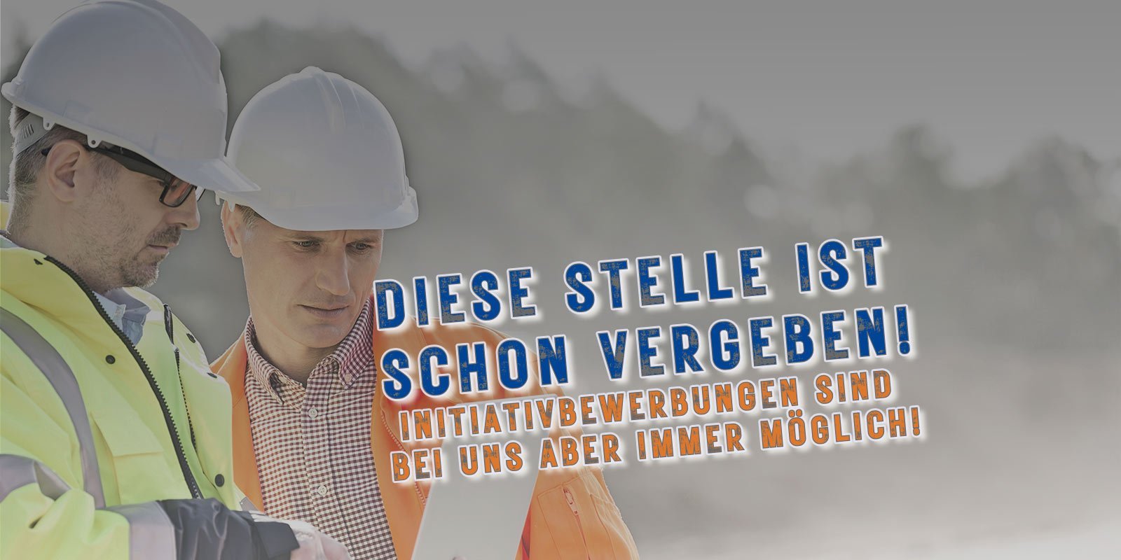 Zwei Männer in Sicherheitskleidung und Helmen betrachten aufmerksam ein Dokument auf einer Baustelle.