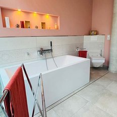 Ein modernes Badezimmer mit einer eleganten weißen Badewanne und einem minimalistischen Design in sanften Farben.