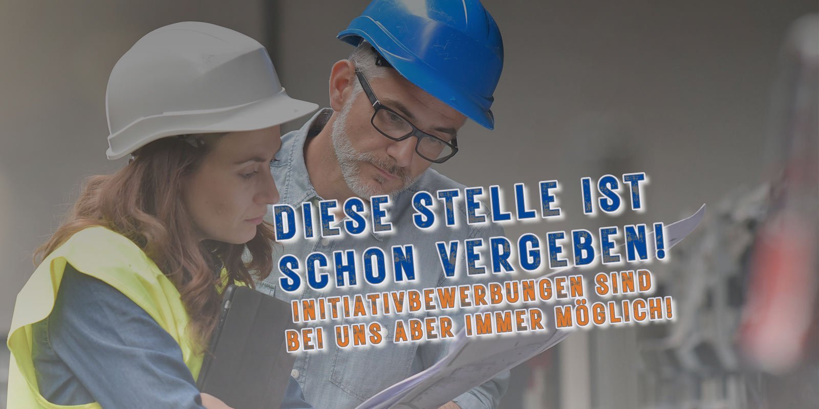 Eine Frau und ein Mann in Schutzhelmen betrachten gemeinsam Dokumente auf einer Baustelle, während sie konzentriert diskutieren.