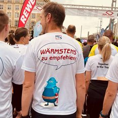 Eine Gruppe von Läufern trägt T-Shirts mit bunten Aufdrucken und bereitet sich auf ein Rennen vor.